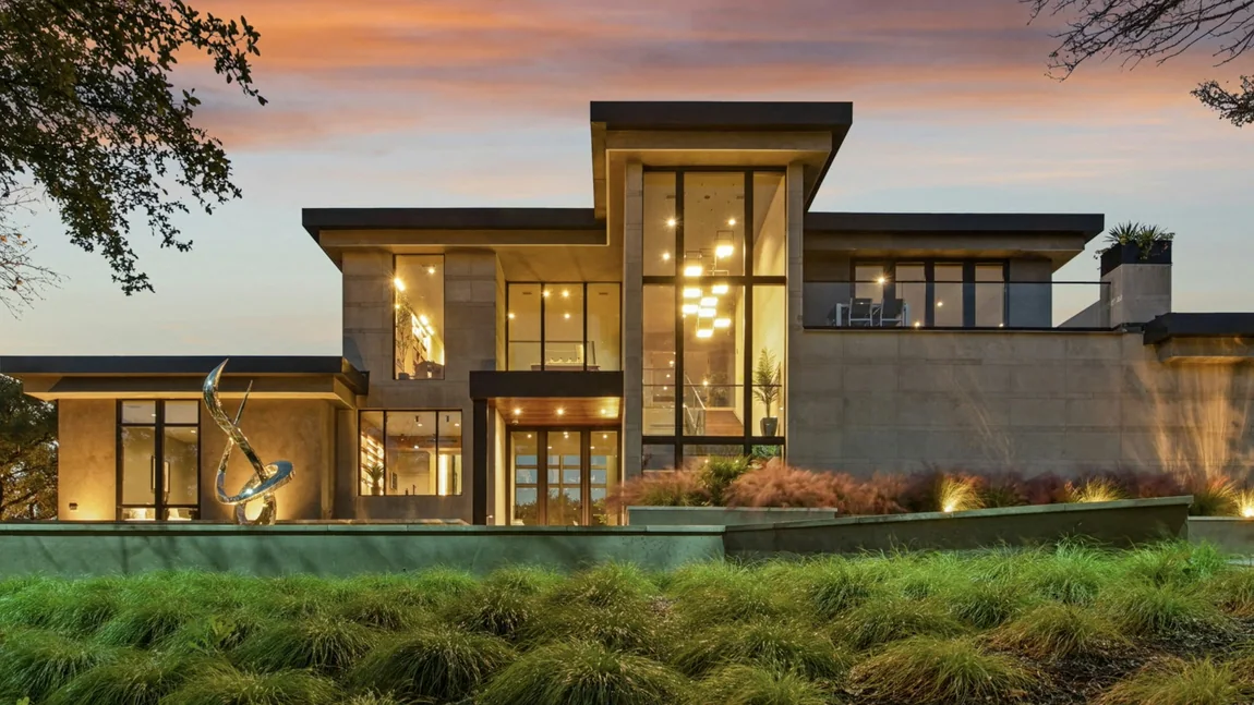 A contemporary house lit from within at dusk.